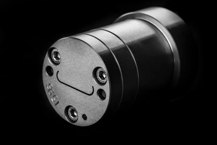 a black plastic extrusion tool with a smiley face