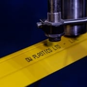 Inline printer writing the words DW plastics ltd